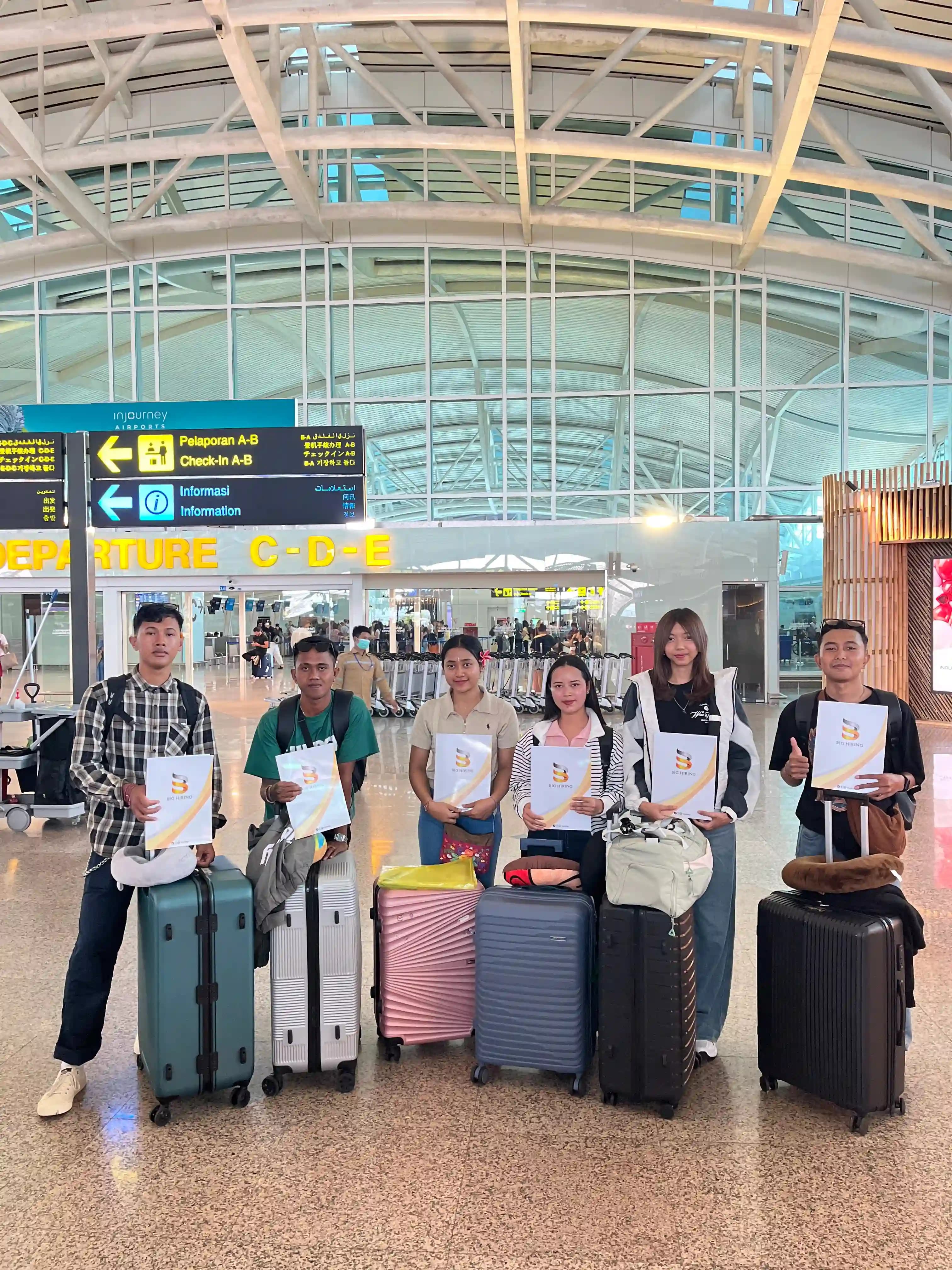 Big Hiring candidates holding placement documents at an airport
